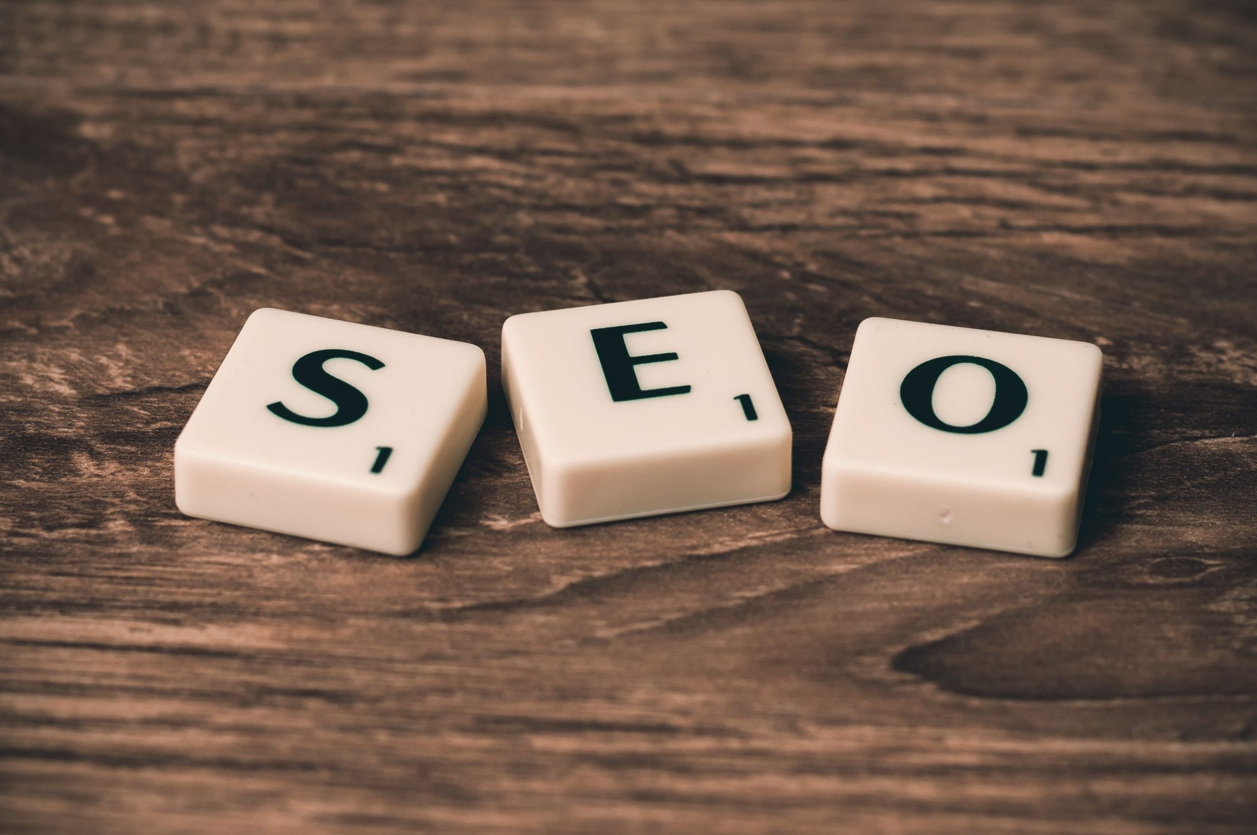seo-myths-digital-marketing-tiles Scrabble tiles spelling SEO on a wooden surface, representing common SEO myths